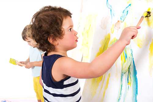 Female house painter paints wall